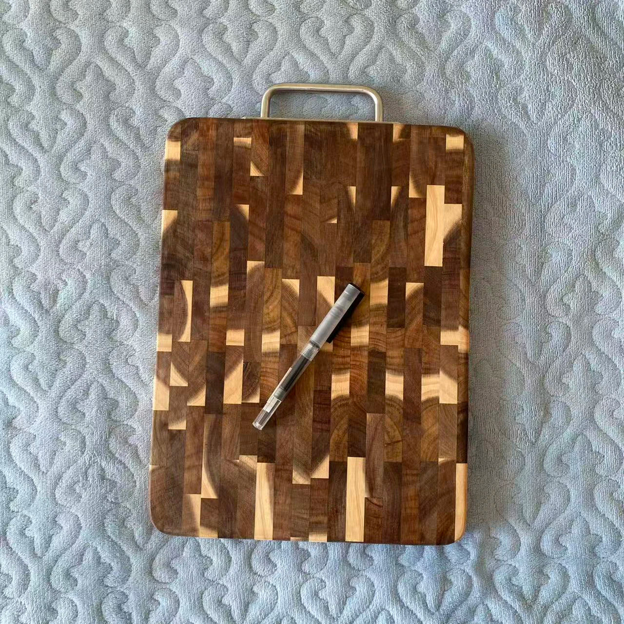 The cutting board is made of solid wood, acacia wood, with dark checkered patterns and fruit wood Chopping board